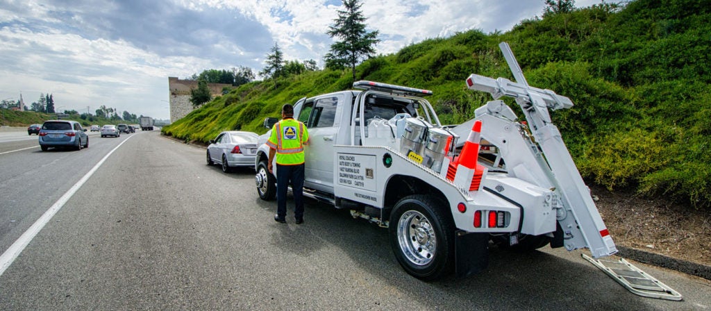 Photo of a Freeway Service vehicle parked on the side of a highway behind a car