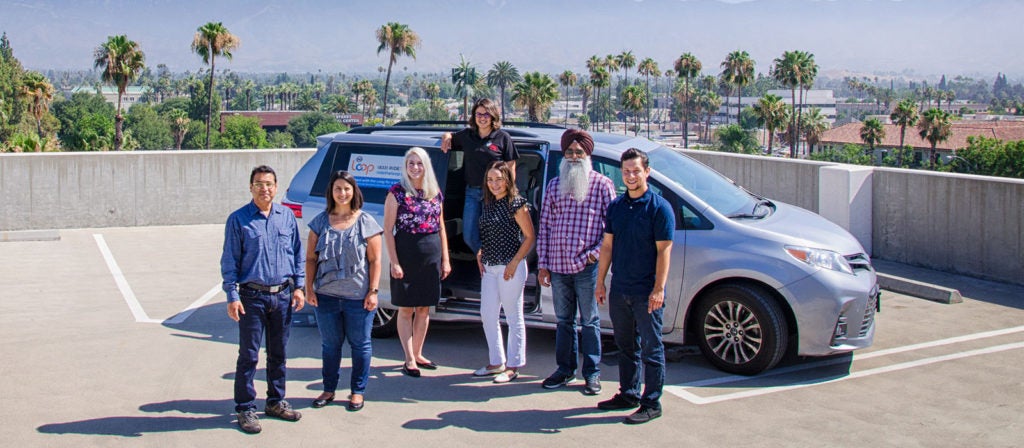 People standing in front of a car