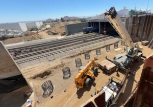 Crews construct a support wall for the future Cedar Avenue bridge over the UPRR.