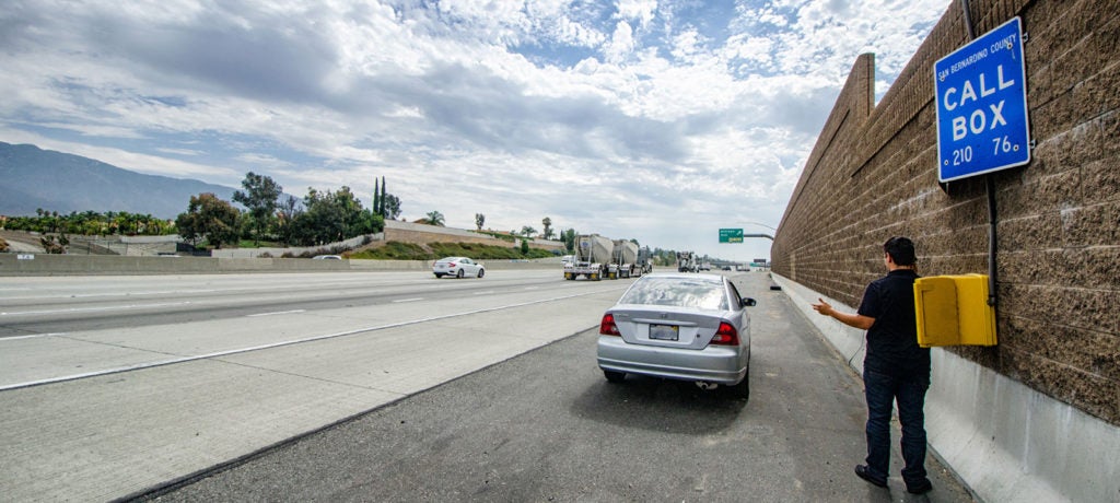 Photo of a car parked on the side of a highway, and a map using the call box 